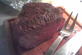the cooked roast, dark on the outside, pink in the inside